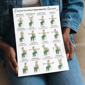May include: A white printed sheet titled "Seated Dumbbell Exercises for Seniors" held by a person. The sheet features illustrations of exercises, including bicep curls, shoulder press, front raises, and lateral raises. The exercises are designed for seniors.