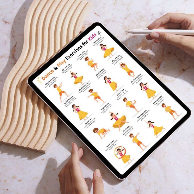 May include: A digital tablet displaying "Dance & Play Exercises for Kids." The screen shows illustrated dance moves with accompanying text. The tablet is held by a person, with a wooden decorative element in the background.