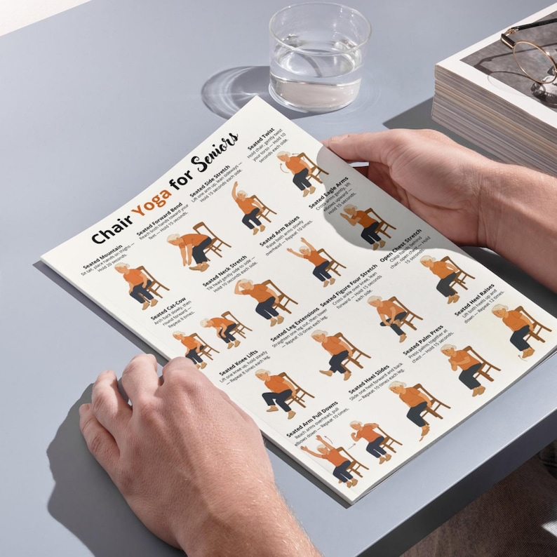 Puede incluir: Una persona sostiene una gu&iacute;a impresa titulada "Chair Yoga for Seniors". La gu&iacute;a presenta ilustraciones de varias posturas de yoga sentado, incluyendo estiramientos y ejercicios. La gu&iacute;a est&aacute; sobre una superficie gris con un vaso de agua y una pila de papeles.