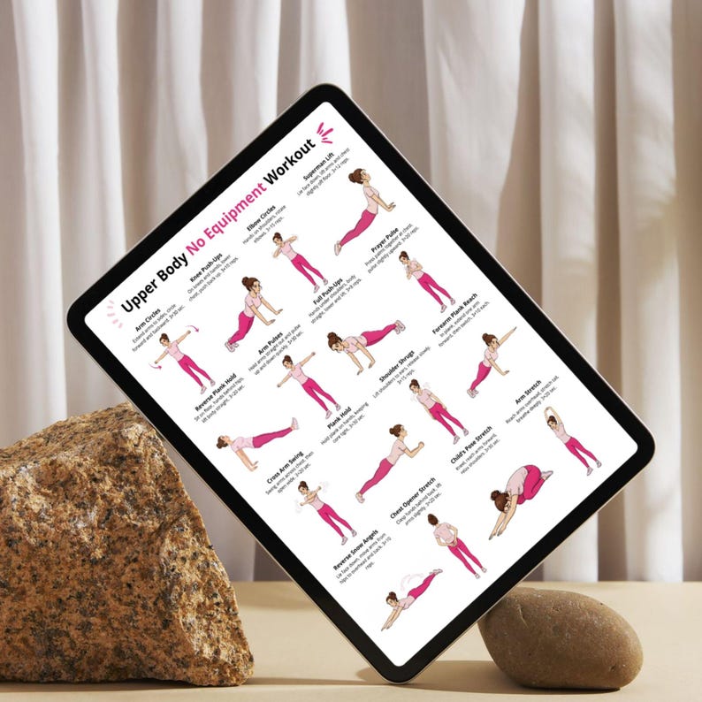 May include: A digital tablet shows an "Upper Body No Equipment Workout" guide. The guide features illustrated exercises in pink, including arm circles, push-ups, and stretches. The tablet is propped up on a stone.
