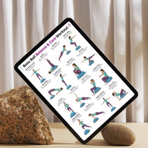 May include: A digital tablet showing a "Bosu Ball Balance & Core Workout" guide. The guide features illustrated exercises with women demonstrating balance and core training moves. The tablet is propped up on a stone, with a neutral background.