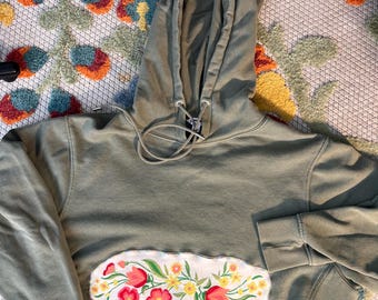 Sudadera corta verde con apliques florales bordados reciclados.