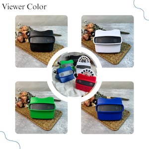 May include: A collection of retro-style viewers in various colors, including black, white, green, blue, and red. Each viewer has a rectangular shape with a viewing lens and a knob on the side. The text "Viewer Color" is at the top.