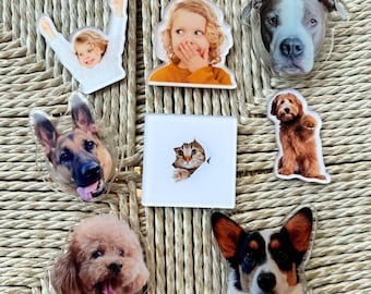 May include: A selection of clear acrylic magnets with diverse images. The magnets showcase portraits of dogs, a cat, and two children. The dog breeds include a German Shepherd, a Poodle, a Corgi, and a Pitbull. The children are shown in playful poses.