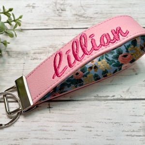 wristlet keychain with custom name. Made with vinyl and fabric inside. Many colors to choose from. Now offering gold hardware