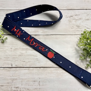 Teacher Name Lanyard for ID holder comes with embroidered apple. Fabric is navy dot. Neck strap for ID badge