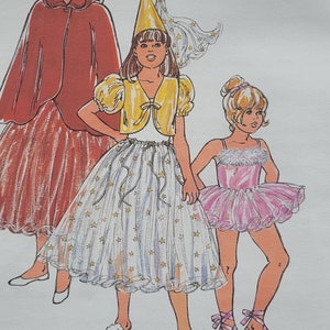 May include: A Kwik Sew pattern envelope 2618 for sizes 4-6-8-10-12. The front features illustrations of three costumes: a red hooded cape, a yellow bolero with a star-patterned skirt and cone hat, and a pink tutu with a feathered trim and ballet slippers.