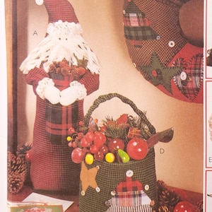 May include: A vintage McCall's Crafts sewing pattern for making Christmas decorations. The pattern includes instructions for making a Santa, a Christmas tree, a snowman, a basket, and a wreath. The pattern number is 8328.