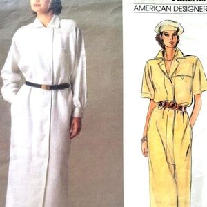 Peut inclure: Patron de couture Vogue Patterns avec des modèles Anne Klein. Le patron présente des illustrations d'une robe blanche à manches longues et d'une robe jaune à manches courtes, toutes deux ceinturées. Le logo Vogue et le texte "American Designer" sont visibles.