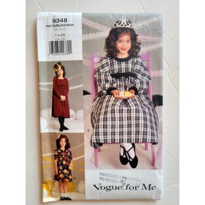 May include: Vogue for Me pattern packet 9348 for girls' dresses, sizes 5-6X. The cover shows three dress designs, including a plaid dress with a crown, a red dress, and a floral dress. The packet includes a barcode and the text "PATTERN/PATRON".