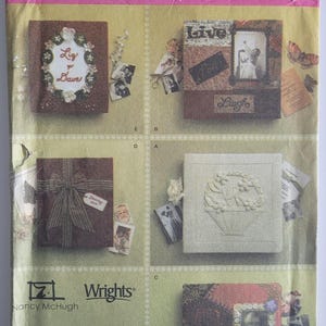 May include: Simplicity scrapbook covers pattern showing four scrapbook cover designs. The covers feature decorative elements such as floral wreaths, bows, and framed photos. The pattern includes the text "Live" and "Laugh".