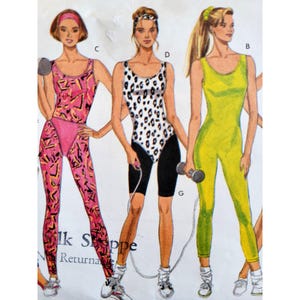 May include: Illustration of three women in athletic wear. One wears a pink and black patterned jumpsuit, another a white and black leopard print leotard with black shorts, and the third a yellow jumpsuit. Each is holding exercise equipment.