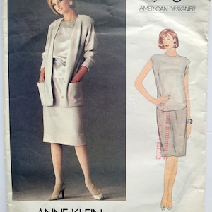 May include: A vintage Very Easy Vogue sewing pattern featuring an Anne Klein design. The pattern includes illustrations of a two-piece suit and a sleeveless top with a skirt. The cover is light beige with text in black and red.