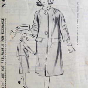 May include: Vintage sewing pattern featuring a fashion illustration of a woman in a coat with a matching hat and purse. The pattern is labeled "NA-2114" and includes the text "PATTERNS ARE NOT RETURNABLE FOR EXCHANGE".