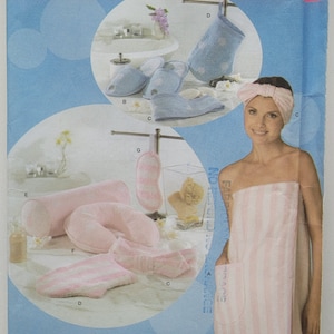 Pode incluir: Um padrão de costura Simplicity para um roupão de spa, uma faixa de cabeça, uma máscara para os olhos, pantufas e um travesseiro para o pescoço. O padrão é rosa e branco com um design listrado. O número do padrão é 4747.
