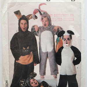 Pode incluir: Um envelope de molde de costura Simplicity apresentando quatro fantasias de animais: um canguru preto com bolsa, um coelho cinza com orelhas longas, um panda preto e branco e um macacão com estampa de leopardo e orelhas. Inclui tamanhos 2-4.