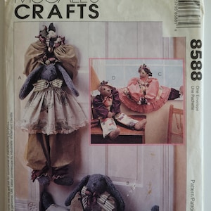 May include: A sewing pattern for making four stuffed bunny toys. The pattern is called "One Envelope Une Pochette" and is by/par Faye Wine. The pattern includes instructions for making a bunny with a dress, a bunny with a hat, a bunny with a skirt, and a bunny with a bow tie.