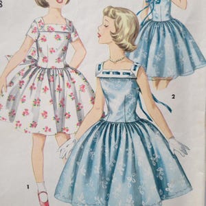 May include: Vintage illustration of three dresses. One dress is white with pink floral print, and the other two are light blue with white floral patterns. The dresses have square necklines and full skirts, with bows at the back. The illustration is a fashion design from a bygone era.
