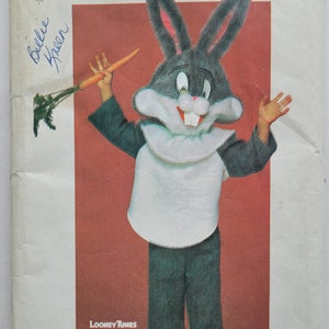 May include: A vintage sewing pattern for a Bugs Bunny costume. The pattern features a cartoon illustration of Bugs Bunny wearing a white shirt and black pants. The pattern is titled "Bugs Bunny" and includes the text "Official Licensed Warner Bros. Product TM and Warner Bros Inc 1974, 1978".