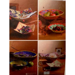 May include: A collection of handmade fabric bowls in various shapes and sizes. The bowls feature colorful patterns and textures, with some containing fruit and decorative items. The image showcases the versatility and aesthetic appeal of these handcrafted items.