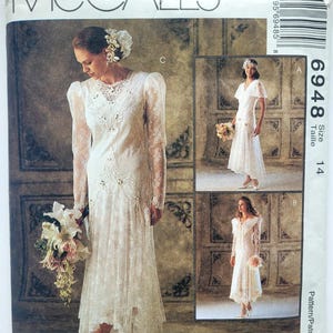 May include: McCall's sewing pattern for bridal gowns, showcasing three dress styles. The primary image displays a bride in a long-sleeved lace dress with floral details. The pattern number is 6948, with the Alicyn Exclusives logo.