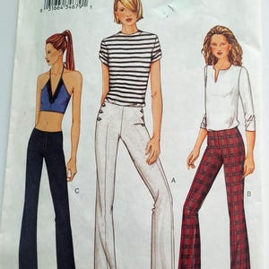 May include: Vogue pattern 7573 featuring illustrations of three different outfits. The outfits include a halter top with flared jeans, a striped t-shirt with white pants, and a white top with plaid pants. The pattern includes sizes 12, 14, and 16.