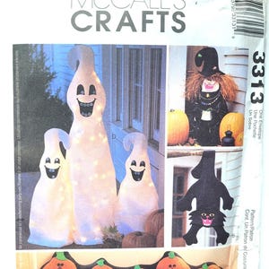 May include: McCall's Crafts Halloween pattern envelope featuring various spooky decorations. The image showcases a variety of Halloween-themed crafts, including smiling ghosts, a witch, a black cat, and pumpkin decorations. The envelope has the number 3313.