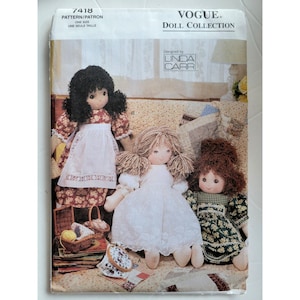 Könnte beinhalten: Vogue Doll Collection Schnittmuster mit drei handgefertigten Puppen. Die Puppen haben Stoffkleider und Garnhaare. Das Muster wurde von Linda Carr entworfen und ist in Einheitsgröße erhältlich.