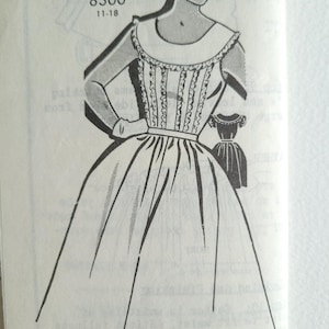 May include: A black and white illustration of a dress pattern with a wide, full skirt and a fitted bodice. The dress has a Peter Pan collar and a decorative trim around the neckline and bodice. The pattern number is 8300 and the size range is 11-18.