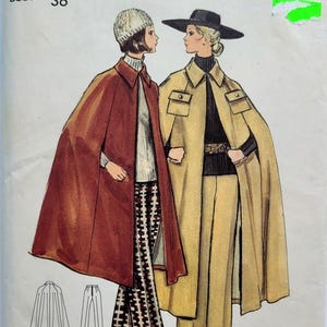 Könnte beinhalten: Vintage Butterick Schnittmuster mit zwei Frauen, die Capes und Hosen tragen. Das Muster enthält einen rostfarbenen Umhang, einen beigefarbenen Umhang und passende Hosen. Der Brustumfang beträgt 91 cm. Das Muster stammt aus den 1970er Jahren.