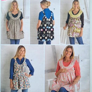 May include: Simplicity sewing pattern 2390 featuring aprons in various floral and patterned fabrics. The pattern includes multiple apron styles with different necklines and pocket designs. The image shows women wearing the aprons.