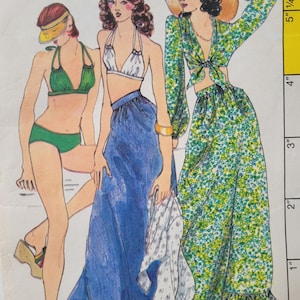 May include: Illustration of three figures in swimwear and beach attire. One figure wears a green bikini, another a white halter top and blue skirt, and the third a green floral print outfit with a wide-brimmed hat. The image is a vintage fashion illustration.