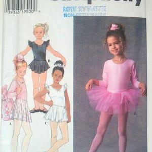 May include: Simplicity sewing pattern 7351 for children's dancewear in size BB 5, 6, 7, 8. The envelope features illustrations of leotards with skirts and a photograph of a child wearing a long-sleeved pink leotard with a matching pink tulle tutu.