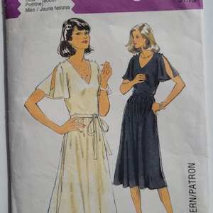 May include: A vintage sewing pattern for a dress with a wrap style skirt and a V-neckline. The pattern is for size 8, bust 80cm, and is for a young woman. The pattern is called "Style" and has a price of $1.75.