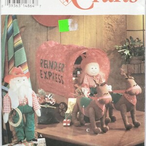 May include: Simplicity Crafts pattern with a Christmas theme. The pattern includes instructions for making a Santa Claus doll, reindeer, and a "Reindeer Express" wagon. The cover art showcases the finished crafts, with a rustic, festive aesthetic.