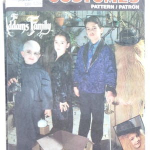 May include: Simplicity Costumes pattern featuring The Addams Family. The image shows children dressed as characters from the movie. The pattern includes instructions for costumes of Gomez, Morticia, Wednesday, and Lurch.