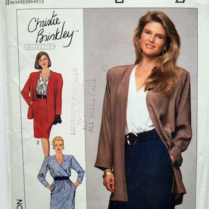 Könnte beinhalten: Simplicity Schnittmuster aus der Christie Brinkley Kollektion. Das Muster zeigt einen Hosenanzug und ein Wickelkleid. Das Cover zeigt eine Frau in einer braunen Jacke, einem weißen Oberteil und einem marineblauen Rock. Größe U5 (16-24).