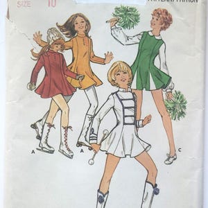 May include: Vintage Butterick sewing pattern featuring illustrations of girls in various outfits. The girls are depicted in a red coat, an orange dress, a green dress, and a white uniform. The pattern number is 4936, and the size is 10.