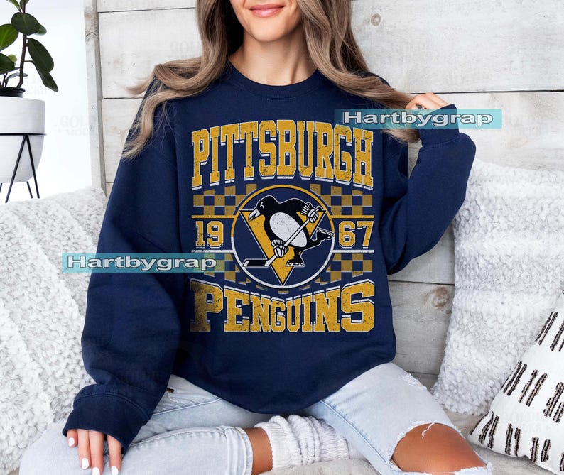 Pu&ograve; includere: Felpa blu navy con il logo dei Pittsburgh Penguins in oro e bianco. Il logo include un pinguino che gioca a hockey, l'anno 1967 e il nome della citt&agrave;. Girocollo e maniche lunghe.