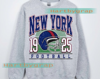 May include: A light gray sweatshirt with a vintage-style graphic. The design features the words "NEW YORK" in blue and red, a football helmet, the numbers "1925", and the word "FOOTBALL". The text "CUSTOM YEAR" is also visible.