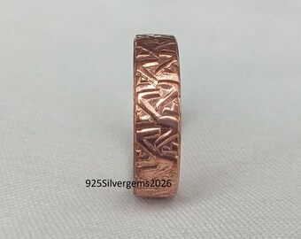 Könnte beinhalten: Ein kupferfarbener Ring mit strukturierter Oberfläche. Der Ring hat ein sich wiederholendes geometrisches Muster. Der Text "925Silvergems2026" ist auf dem Ring sichtbar. Der Ring wird auf einer hellgrauen Oberfläche präsentiert.