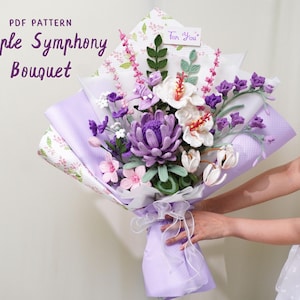 May include: A handmade bouquet of crochet flowers in shades of purple, pink, and white, wrapped in lavender paper. The bouquet includes a variety of flower types, with the text "PDF Pattern Purple Symphony Bouquet" visible. A small card reads "For You".