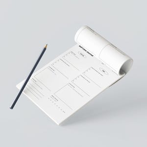 Peut inclure: Un journal de soins personnels blanc avec un crayon bleu foncé. Le journal est ouvert, révélant des sections pour les réflexions quotidiennes. Le texte "Self Care Journal" est imprimé en haut. Le crayon est bleu foncé.