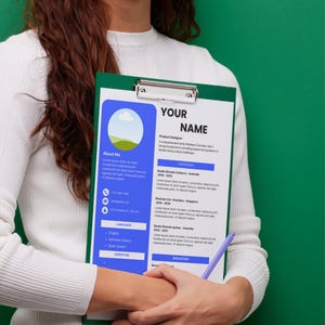 Peut inclure: Une personne tient un presse-papiers vert avec un CV. Le CV a un design bleu et blanc avec le texte "YOUR NAME" en haut. Un stylo violet est tenu à côté du CV. Le fond est vert uni.