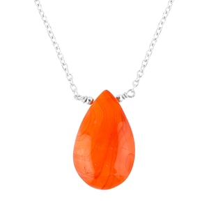 Silver tone chain necklace displaying carnelian teardrop polished gemstone encouraging creativity strength emotional balance