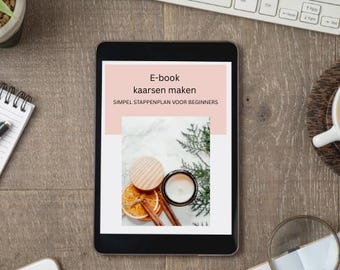 May include: A black tablet displays an e-book titled "kaarsen maken" with the subtitle "SIMPEL STAPPENPLAN VOOR BEGINNERS." The image on the tablet shows a candle, dried orange slices, and cinnamon sticks. A keyboard, notepad, and magnifying glass are also visible.