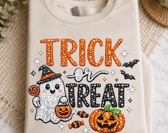 May include: A beige crewneck sweatshirt featuring a graphic print with the text TRICK or TREAT. The design includes a white ghost wearing a black hat, a jack-o'-lantern, small candies, and bats, all rendered in a textured, beaded-style pattern.