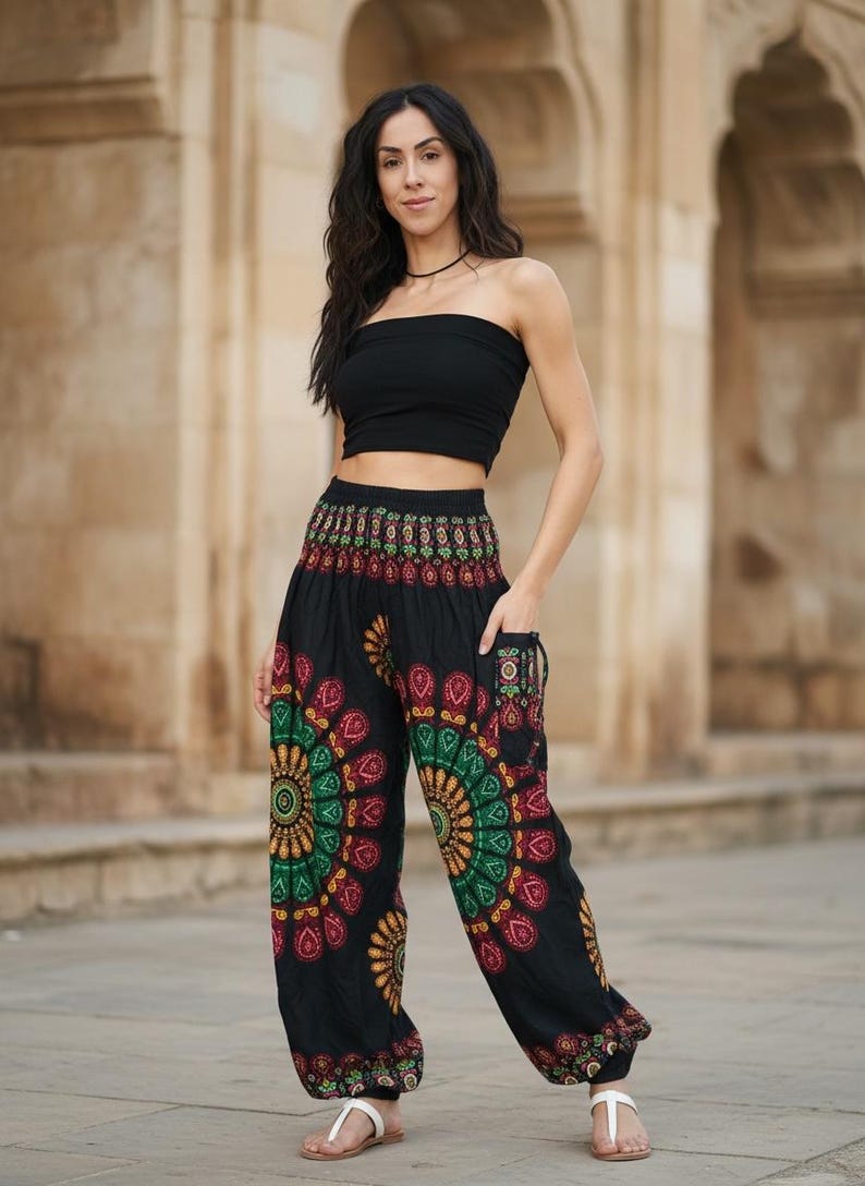 Puede incluir: Pantalones harem negros con un colorido dise&ntilde;o de mandala en rojo, verde y amarillo. Los pantalones tienen bolsillos y se combinan con un top de tubo negro. El conjunto es casual y bohemio.