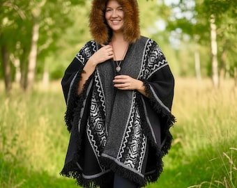 Poncho de lana tejido a mano con capucha de piel sintética negra y gris, ideal para festivales de invierno.