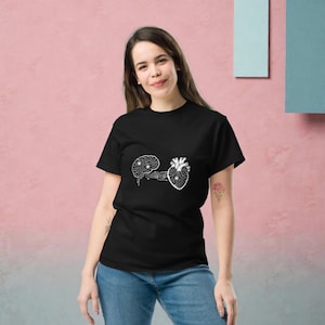 May include: Black t-shirt featuring a white graphic of a brain connected to a heart, both with circuit board designs. The shirt is made of a soft material and is suitable for casual wear.